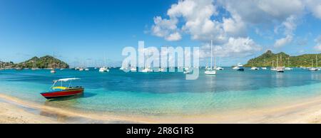 Türkisfarbenes Meer mit angehängten Yachten und Booten in der Lagune mit Sandstrand auf der Insel Carriacou, Grenada, Karibik Stockfoto