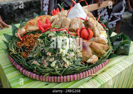 Nasi Tumpeng (Konusreis) serviert mit Urap-Urap (indonesischer Salat), gebratenes Hähnchen und Nudeln Nasi Tumpeng wird in der Regel auf Geburtstagsfeiern oder Th serviert Stockfoto