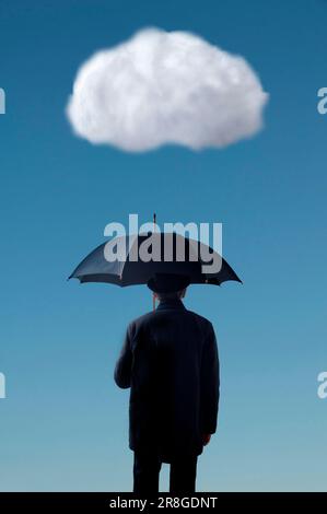 Ein Mann mit Anzug und Hut, der einen Regenschirm unter einer weißen Wolke hält Stockfoto