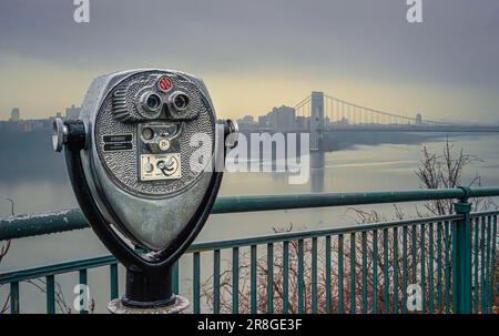 Münzbetriebener Sucher im Palisades Park über dem Hudson River mit Blick auf die George Washington Bridge bei Regen und Nebel. Stockfoto