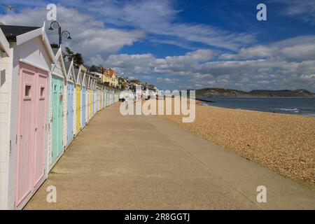 Farbenfrohe Strandhütten neben dem Kiesstrand am Lyme Regis an der Jurassic Coast, Dorset, England, Großbritannien Stockfoto