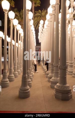 26. April 2023, Los Angeles, Kalifornien, USA: Touristen und Besucher in Downtown Los Angeles besuchen Urban Light bei Nacht... Urban Light ist eine große Skulptur von Chris Burden, die aus 202 restaurierten Straßenlampen aus den 1920er und 1930er Jahren besteht. Die Lampen sind in einem Gitter am Eingang zum Los Angeles County Museum of Art (LACMA) angeordnet. Die Skulptur ist solarbetrieben und leuchtet von der Dämmerung bis zum Morgengrauen. (Kreditbild: © Taidgh Barron/ZUMA Press Wire) NUR REDAKTIONELLE VERWENDUNG! Nicht für den kommerziellen GEBRAUCH! Stockfoto