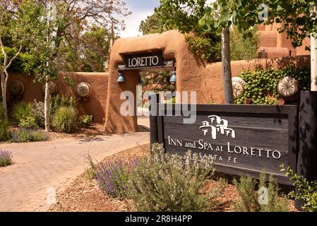 Adobe Wall, Landschaftsgestaltung und Schild am Eingang zum Inn and Spa at Loretto, einem Luxushotel in Santa Fe, New Mexico, USA. Stockfoto