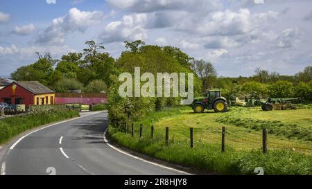 Heuproduktion auf dem Land (mit grünem Traktor, Straßenfeld, Farmer Swath-making, G & T's Ice Cream Parlour) – Risplith, North Yorkshire, England, Großbritannien. Stockfoto