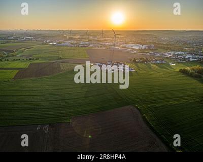 Luftaufnahme von Energy aus Windturbinen bei Sonnenuntergang auf dem Feld. Windmühlen-Farm. Sonnenuntergang auf dem Land, Konzept für nachhaltige saubere Energie, von einer Drohne erschossen. Hochwertiges Foto Stockfoto
