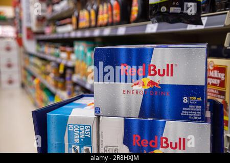 8 Dosen Red Bull werden im Lebensmittelgeschäft ausgestellt. Red Bull ist eine beliebte Energy-Drink-Marke des österreichischen Unternehmens Red Bull GmbH. Stockfoto