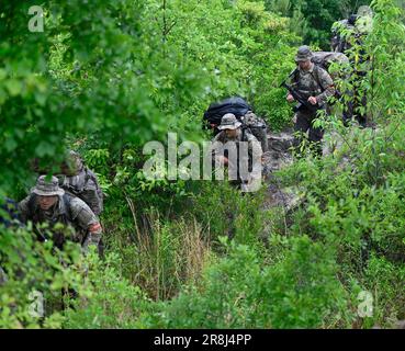 27. Mai 2023 - Hoffman, North Carolina, USA - Spezialeinsatzkandidaten für die USA Army John F. Kennedy Special Warfare Center and School Knie nieder, während sie in der letzten Phase des Feldtrainings, bekannt als Robin Sage, in der Mitte von North Carolina am 27. Mai 2023 durch ein bewaldetes Gebiet wandern. Robin Sage ist die Kulminationsübung für Soldaten im Qualifizierungskurs der Spezialkräfte und ist seit mehr als 50 Jahren der Lackmustest für Soldaten, die sich die Green Beret verdienen wollen. (Kreditbild: © K. Kassens/USA Army/ZUMA Press Wire Service) NUR FÜR REDAKTIONELLE ZWECKE! Nicht für gewerbliche VERWENDUNG Stockfoto