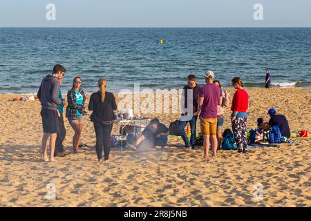 Bournemouth, Dorset, Großbritannien. 21. Juni 2023 Britisches Wetter: Warme, milde Abende an den Stränden von Bournemouth, während Besucher das warme Wetter am Meer genießen. Gruppe mit Barbecue am Strand. Kredit: Carolyn Jenkins/Alamy Live News Stockfoto