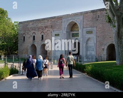 Besucher verlassen das Kaisertor, das äußerste Tor des Topkapi-Palastes, der historischen osmanischen Anlage, Istanbul, Türkei. Stockfoto