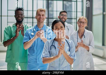 Professionelle multinationale Ärzte applaudieren vor der Kamera. Diagnosediskussion Stockfoto