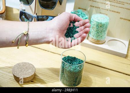Die Hand einer Person, die während der Revolution Plastics Future Conference der University of Portsmouth in Portsmouth recycelte Plastikpellets aus verlassenen Fischernetzen eingießt, die an den Küsten von Cornwall, Newquay, gesammelt wurden. Waterhaul, ein in Großbritannien ansässiges Sozialunternehmen in Cornish, bekämpft die Plastikverschmutzung durch weggeworfene Fanggeräte, indem es diese in recycelte Sonnenbrillen umwandelt. Die internationale Plastics Future Conference wurde veranstaltet, um globale Forschung und Innovation über verschiedene Disziplinen und Gemeinschaften hinweg auszutauschen, um das Problem der globalen Kunststoffverschmutzung anzugehen. (Foto: James Wakibia/SOPA Images/Sipa Stockfoto