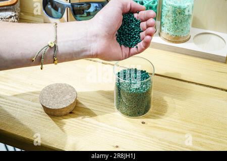 Die Hand einer Person, die während der Revolution Plastics Future Conference der University of Portsmouth in Portsmouth recycelte Plastikpellets aus verlassenen Fischernetzen eingießt, die an den Küsten von Cornwall, Newquay, gesammelt wurden. Waterhaul, ein in Großbritannien ansässiges Sozialunternehmen in Cornish, bekämpft die Plastikverschmutzung durch weggeworfene Fanggeräte, indem es diese in recycelte Sonnenbrillen umwandelt. Die internationale Plastics Future Conference wurde veranstaltet, um globale Forschung und Innovation über verschiedene Disziplinen und Gemeinschaften hinweg auszutauschen, um das Problem der globalen Kunststoffverschmutzung anzugehen. (Foto: James Wakibia/SOPA Images/Sipa Stockfoto