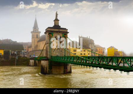 Blick auf Seyssel auf der Rhone mit Kirche Saint-Blaise und Hängebrücke im Winter Stockfoto