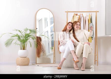 Wunderschöne junge Schwestern machen Selfie in der Garderobe Stockfoto