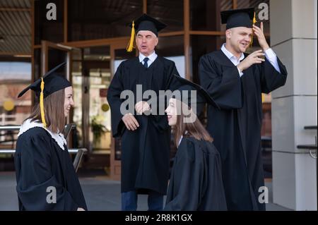 Klassenkameraden in Abschlusskleidern. Barrierefreie Bildung für alle Altersgruppen. Stockfoto