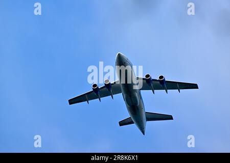 Ein Pendler-Passagierflugzeug, das in einem wolkengefüllten Himmel fliegt Stockfoto