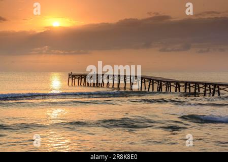 Sommersonnenaufgang auf einem hölzernen Pier an einem Strand in Platja de Muro (Mallorca, Balearen, Spanien) ESP: Amanecer veraniego en un muelle de madera en Muro Stockfoto