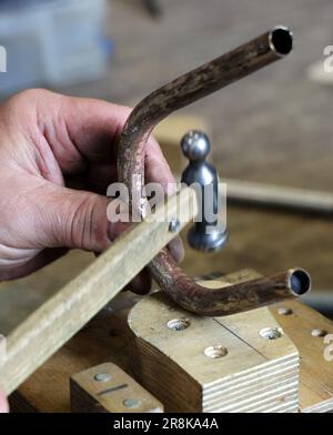 Rostock, Deutschland. 21. Juni 2023. Auf dem 19. Internationalen Workshop für die Trompetenherstellung im Handwerkertrainingscenter bauen die zehn Teilnehmer aus Deutschland, Spanien, Dänemark und den USA eine lange Trompete (ohne Löcher), die auf einem Original von Hans Hainlein aus dem Jahr 1632 unter fachkundiger Anleitung von Michael Münkwitz, Meisterhandwerker in der Herstellung von Metall- und Holzwindgeräten, innerhalb einer Woche. Münkwitzt hat in den letzten Jahren mehr als 850 Werkstattteilnehmer aus der ganzen Welt betreut. Kredit: Bernd Wüstneck/dpa/Alamy Live News Stockfoto