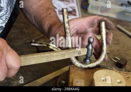 Rostock, Deutschland. 21. Juni 2023. Auf dem 19. Internationalen Workshop für die Trompetenherstellung im Handwerkertrainingscenter bauen die zehn Teilnehmer aus Deutschland, Spanien, Dänemark und den USA eine lange Trompete (ohne Löcher), die auf einem Original von Hans Hainlein aus dem Jahr 1632 unter fachkundiger Anleitung von Michael Münkwitz, Meisterhandwerker in der Herstellung von Metall- und Holzwindgeräten, innerhalb einer Woche. Münkwitzt hat in den letzten Jahren mehr als 850 Werkstattteilnehmer aus der ganzen Welt betreut. Kredit: Bernd Wüstneck/dpa/Alamy Live News Stockfoto