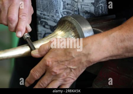 Rostock, Deutschland. 21. Juni 2023. Auf dem 19. Internationalen Workshop für die Trompetenherstellung im Handwerkertrainingscenter bauen die zehn Teilnehmer aus Deutschland, Spanien, Dänemark und den USA eine lange Trompete (ohne Löcher), die auf einem Original von Hans Hainlein aus dem Jahr 1632 unter fachkundiger Anleitung von Michael Münkwitz, Meisterhandwerker in der Herstellung von Metall- und Holzwindgeräten, innerhalb einer Woche. Münkwitzt hat in den letzten Jahren mehr als 850 Werkstattteilnehmer aus der ganzen Welt betreut. Kredit: Bernd Wüstneck/dpa/Alamy Live News Stockfoto