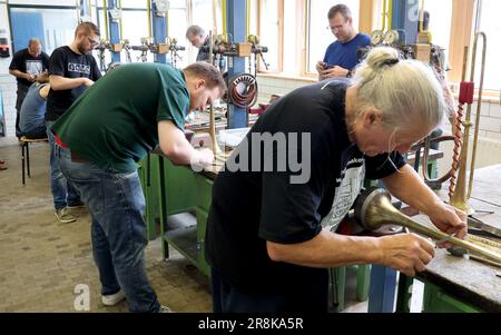 Rostock, Deutschland. 21. Juni 2023. Auf dem 19. Internationalen Workshop für die Trompetenherstellung im Handwerkertrainingscenter bauen die zehn Teilnehmer aus Deutschland, Spanien, Dänemark und den USA eine lange Trompete (ohne Löcher), die auf einem Original von Hans Hainlein aus dem Jahr 1632 unter fachkundiger Anleitung von Michael Münkwitz, Meisterhandwerker in der Herstellung von Metall- und Holzwindgeräten, innerhalb einer Woche. Münkwitzt hat in den letzten Jahren mehr als 850 Werkstattteilnehmer aus der ganzen Welt betreut. Kredit: Bernd Wüstneck/dpa/Alamy Live News Stockfoto