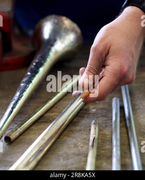 Rostock, Deutschland. 21. Juni 2023. Auf dem 19. Internationalen Workshop für die Trompetenherstellung im Handwerkertrainingscenter bauen die zehn Teilnehmer aus Deutschland, Spanien, Dänemark und den USA eine lange Trompete (ohne Löcher), die auf einem Original von Hans Hainlein aus dem Jahr 1632 unter fachkundiger Anleitung von Michael Münkwitz, Meisterhandwerker in der Herstellung von Metall- und Holzwindgeräten, innerhalb einer Woche. Münkwitzt hat in den letzten Jahren mehr als 850 Werkstattteilnehmer aus der ganzen Welt betreut. Kredit: Bernd Wüstneck/dpa/Alamy Live News Stockfoto