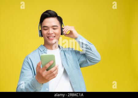 Kopfhörer für junge Männer hören Musik singen Songs und zeichnen Stimmen von isolierten Mobiltelefonen auf Stockfoto