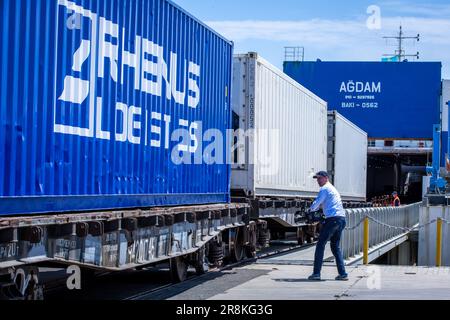 Kuryk, Kasachstan. 21. Juni 2023. Güterwagen mit Containern werden im Fährhafen Kuryk auf ein Fährschiff verladen und über das Kaspische Meer transportiert. Für den Güterverkehr zwischen Asien und Europa gewinnt der so genannte mittlere Korridor zunehmend an Bedeutung. Die Route verläuft durch Zentralasien und umgeht Russland im Norden und den Iran im Süden. Kredit: Jens Büttner/dpa/Alamy Live News Stockfoto