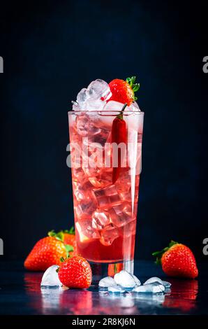 Rotes alkoholisches Cocktailgetränk mit Wodka, Grapefruitsaft, Erdbeeren, Zucker und heißem Chili-Pfeffer. Highball-Glas auf dunkelblauem Hintergrund Stockfoto