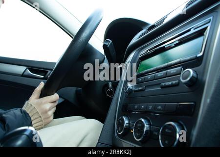 Ein Mädchen, das ihr Auto fährt, fährt einen Roboter, ein Mann in einem Auto Stockfoto