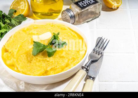 Portioniertes Maismehl, Polenta-Mehl, Haferbrei, Schüssel. Fertig zum Abendessen mit Maiskornbrei mit Butter, Petersilie, Gewürzen Stockfoto