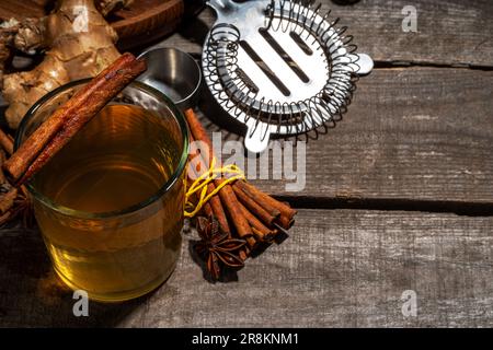 Whiskey Old Fashioned Zimt Stick. Starker Alkoholcocktail mit Zimt und Ingwer, wärmerer Herbstgetränk im Winter, Kopierraum mit Holzhintergrund Stockfoto