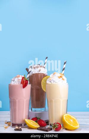 Set aus erfrischenden Sommermilchshakes oder Smoothies mit klassischem, köstlichem Geschmack - Vanille-Zitrone, Erdbeere, Schokolade, mit Schlagsahne und Garnierung, Stockfoto