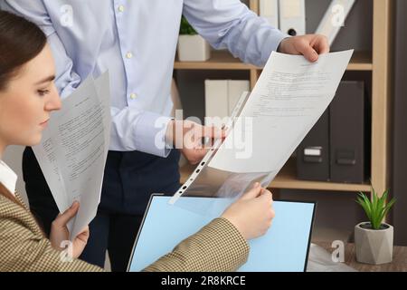 Geschäftsleute, die mit Dokumenten arbeiten, im Büro, in der Nähe Stockfoto