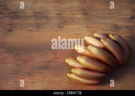 Leckere lila Bananen auf einem Holztisch, Blick von oben. Platz für Text Stockfoto