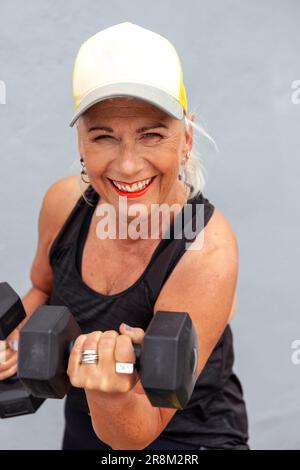 Porträt einer anständigen Seniorin mit coolem Haarschnitt und Kurzhanteln Stockfoto
