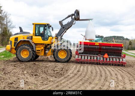 Landwirtschaftliche Maschine, die auf gepflügtem Feld arbeitet Stockfoto