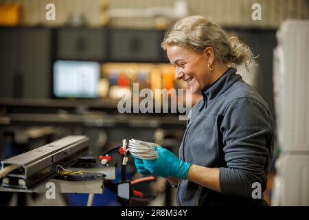 Junge Arbeiterin in der Fabrik Stockfoto