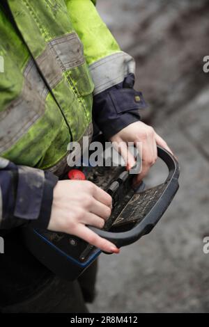 Nahaufnahme des Bauarbeiters mit dem Controller Stockfoto