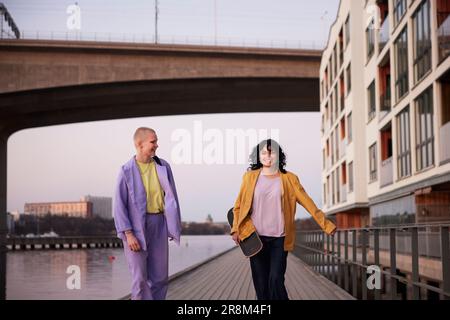 Glückliche junge Frauen, die zusammen am Fluss spazieren Stockfoto