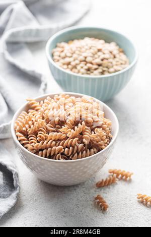 Grüne Linsenfusilli-Pasta. Eine Schüssel mit roher Pasta und grünen Linsen. Glutenfreie Pasta. Stockfoto