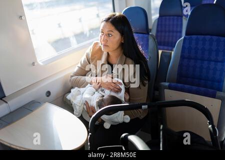 Aus dem Blickwinkel einer Frau im Zug, die ein Baby hält Stockfoto