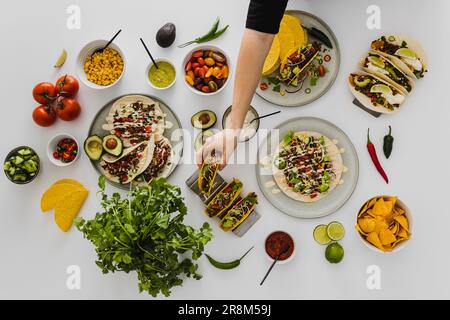 Person bereitet ein gesundes Festmahl mit verschiedenen mexikanischen Speisen zu Stockfoto