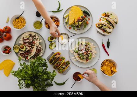 Menschen teilen verschiedene gesunde mexikanische Lebensmittel Stockfoto