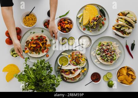 Person bereitet ein gesundes Festmahl mit verschiedenen mexikanischen Speisen zu Stockfoto