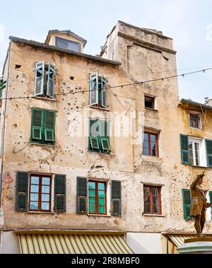 Das schäbige historische Haus mit Einschusslöchern und einem Denkmal für den Helden der korsischen Revolution - General Gaffori, befindet sich auf dem Platz Gaffori Stockfoto