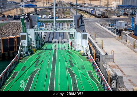 Kuryk, Kasachstan. 21. Juni 2023. Güterwagen mit Containern werden im Fährhafen Kuryk auf ein Fährschiff verladen und über das Kaspische Meer transportiert. Für den Güterverkehr zwischen Asien und Europa gewinnt der so genannte mittlere Korridor zunehmend an Bedeutung. Die Route verläuft durch Zentralasien und umgeht Russland im Norden und den Iran im Süden. Kredit: Jens Büttner/dpa/Alamy Live News Stockfoto