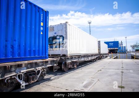 Kuryk, Kasachstan. 21. Juni 2023. Güterwagen mit Containern werden im Fährhafen Kuryk auf ein Fährschiff verladen und über das Kaspische Meer transportiert. Für den Güterverkehr zwischen Asien und Europa gewinnt der so genannte mittlere Korridor zunehmend an Bedeutung. Die Route verläuft durch Zentralasien und umgeht Russland im Norden und den Iran im Süden. Kredit: Jens Büttner/dpa/Alamy Live News Stockfoto