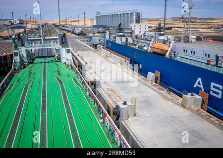 Kuryk, Kasachstan. 21. Juni 2023. Güterwagen mit Containern werden im Fährhafen Kuryk auf ein Fährschiff verladen und über das Kaspische Meer transportiert. Für den Güterverkehr zwischen Asien und Europa gewinnt der so genannte mittlere Korridor zunehmend an Bedeutung. Die Route verläuft durch Zentralasien und umgeht Russland im Norden und den Iran im Süden. Kredit: Jens Büttner/dpa/Alamy Live News Stockfoto