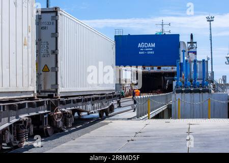 Kuryk, Kasachstan. 21. Juni 2023. Güterwagen mit Containern werden im Fährhafen Kuryk auf eine Fähre verladen und über das Kaspische Meer transportiert. Für den Güterverkehr zwischen Asien und Europa gewinnt der so genannte mittlere Korridor zunehmend an Bedeutung. Die Route verläuft durch Zentralasien und umgeht Russland im Norden und den Iran im Süden. Kredit: Jens Büttner/dpa/Alamy Live News Stockfoto